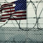 American flag behind barbwire